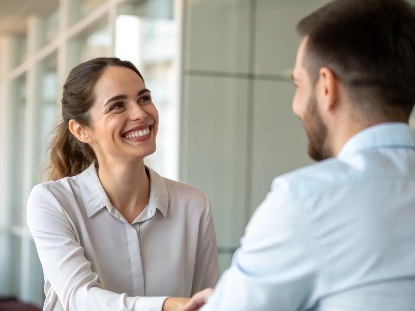 A medium shot of a small business owner shaking hands with a Starsong Capital representative, symbolizing a successful funding partnership.